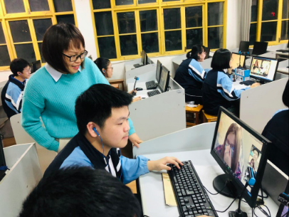 Wang Ling (2018-2019) stands next to one of her students during the virtual bilingual class.