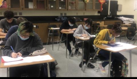 The students are writing words about sports activities on small cards
