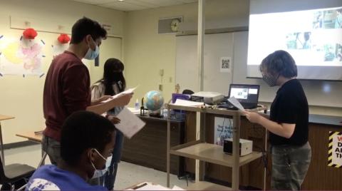 The students are doing a role play to practice the target language: ni hao