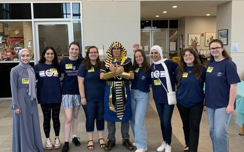 emad gerges poses in egyptian dress with student volunteers