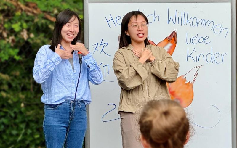 exchange teacher sings next to co-teacher at host school welcome